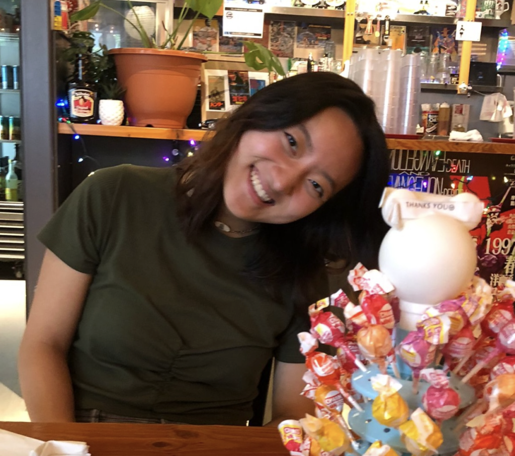 Eleanor Song smiles behind a lollipop stand.